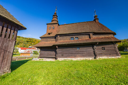 Wooden Church of Saint Michael the Archangel in Rusky Potok, Slovakia, standing tall against a blue sky