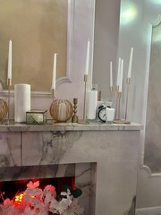 variety of candles and decor on the fireplace
