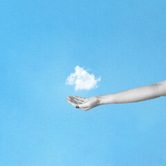 Abstract collage illustration of woman hand holding cloud in blue background. Grunge, noise and grain effect applied. Blue background with copy space. Retro vintage style