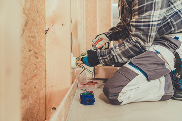 Electrician Performing Wiring Installation in a Residential Construction Site During Daylight Hours
