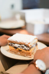 A piece of chocolate pastry cake on a small plate with very melted ovaltine chocolate looks tempting
