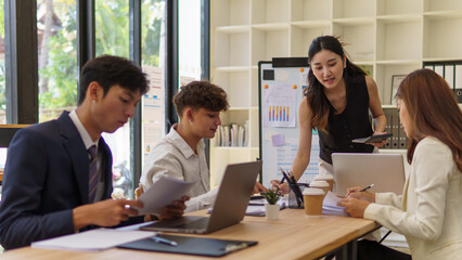 Confident female team leader presenting ideas to colleagues in a collaborative office.