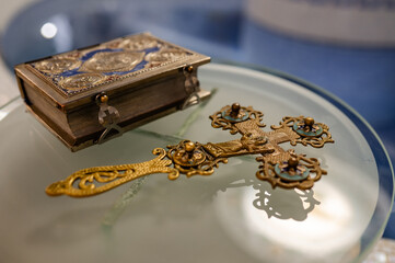 golden gospel cross and other church utensils on a church table in an Orthodox church, preparation for the sacrament of baptism