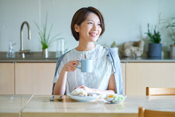 部屋で朝食を食べる女性