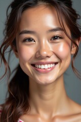 Young Asian woman cheerful with a bright smile against grey studio backdrop with copy space