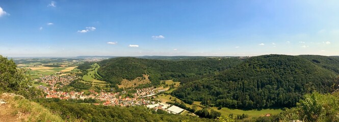 Wide panoramic view of a picturesque village amidst lush green hills