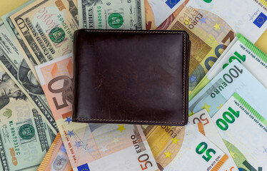 Brown leather wallet lies on banknotes