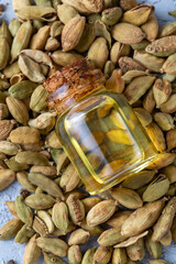Green cardamom essential oil and cardamom pods in glass containers