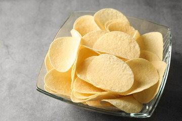 Tasty potato chips on grey table, closeup