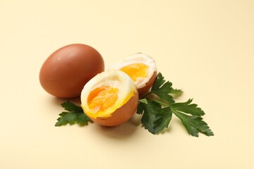 Soft boiled eggs and parsley on beige background, closeup