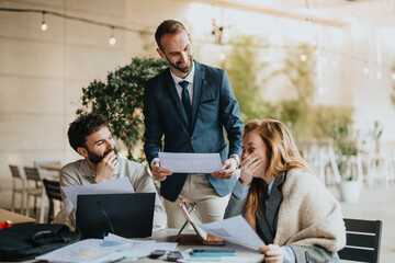 Three professionals collaborating in a modern office environment, engaging in cheerful teamwork and...