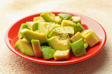 Tasty cut avocados with dressing on light textured table, closeup