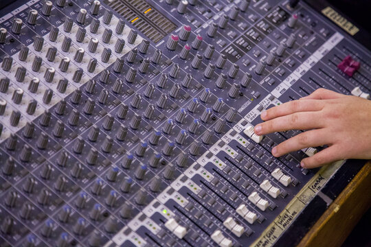 Person adjusting knobs on a sound system