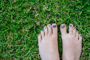 painted patriotic toenails on the grass, union jack for UK, Australia or NZ.