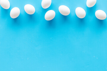 Set of chicken eggs on blue background, top view. Food pattern. Easter background
