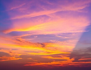 Fototapeta premium A vibrant sky painted with hues of orange, pink, and purple, adorned with fluffy white clouds drifting lazily, creating a stunning sunset backdrop.