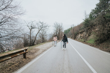 Two individuals take a hike along a quiet road on an overcast day, enjoying nature and...