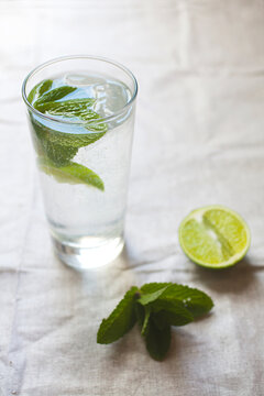 Cool glass of water with ice and mint on tabletop