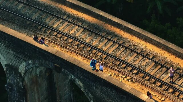 Aerial view of most scenic Nine Arch bridge in mountain jungle of Sri Lanka in Ella. Sunrise illuminates iconic Nine Arch Bridge surrounded by lush greenery. scenic route for travelers