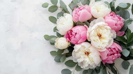 Beautiful arrangement of peonies and eucalyptus leaves on a neutral background