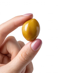 A woman's hand with perfectly manicured nails delicately holds a single green olive against a bright white backdrop, showcasing its smooth surface and golden hue.