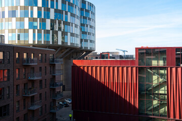 Red geometric panels and blue glass buildings, modern architectural design, ideal for cityscape, geometry, and contemporary architecture stock imagery.
