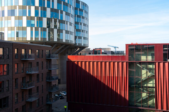 Red geometric panels and blue glass buildings, modern architectural design, ideal for cityscape, geometry, and contemporary architecture stock imagery.