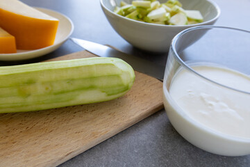 Cream, cheese and peeled zucchini on kitchen counter side view