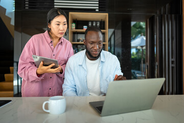 Man and woman working remotely using laptop. Male female freelancers working together. Digital nomad