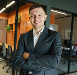 Fototapeta premium Confident professional smiling in a modern office setting with warm colors and sleek design elements
