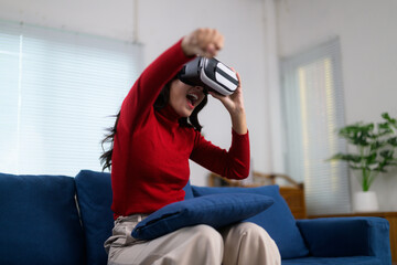 Young woman having fun playing a videogame with a vr headset in her living room