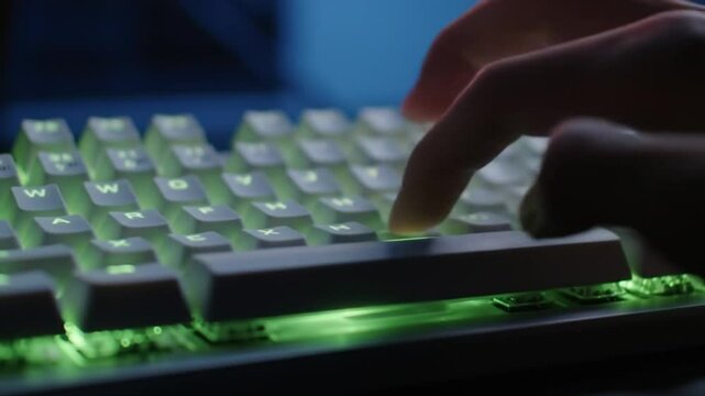 Close-up of a Finger Pressing Spacebar on a Modern Mechanical Keyboard with Vibrant Green Backlighting in a Dark Room