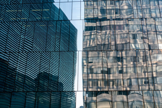 Glass facade reflections of skyscrapers and offices, urban architecture and geometric patterns, ideal for business, background, and cityscape stock photography.