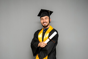 Happy graduate smiling and holding his diploma with pride