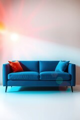 Blue sofa with orange and blue pillows set against a light wall