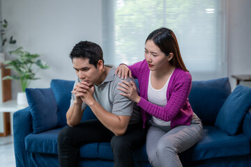 A man and a woman sitting on a blue couch