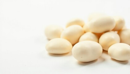 Close-up of several white beans against a bright white backdrop, macro, vegetarian, ingredients