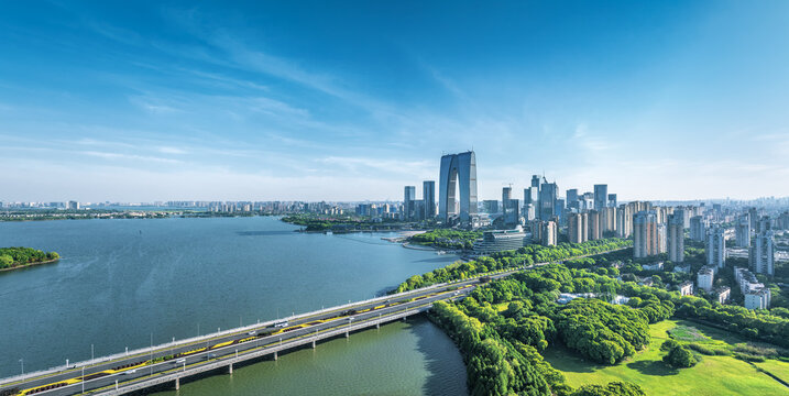 Modern cityscape and financial district skyline with a large lake in Suzhou, China.