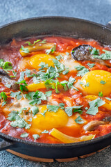 Shakshuka with mushrooms and yellow peppers topped with eggs and cilantro