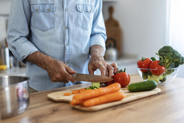 Hands, cutting board and salad in kitchen with vegetables for healthy food or nutrition. Person with culinary skills for cooking lunch with tomato, cucumber and organic ingredients at home.