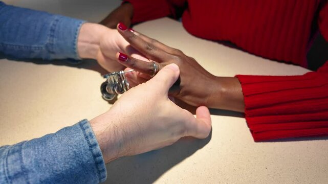 Woman's hand choosing the correct ring size with a ring sizer.