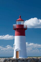 A redandwhite lighthouse stands against a blue sky with scattered white clouds