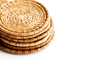 A set of small rattan coasters neatly arranged on a white surface.