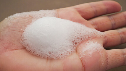 Gentle Foam: A close-up shot captures a perfect cloud of delicate soap foam resting on the palm, highlighting its soft texture, purity, and cleansing properties. 