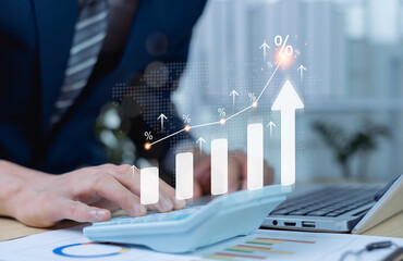 Businessman using calculator with percentage graph symbol and up arrow. Dividends and long term...