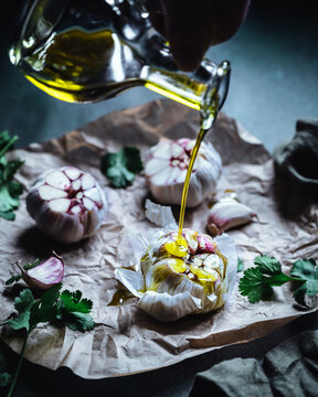 Garlic cloves with olive oil and herbs on paper