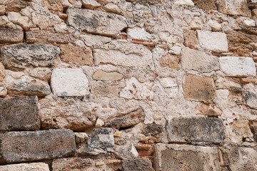 Texture of grey eroded stone on wall