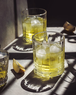 Refreshing lemon liqueur in sunlight with ice cubes