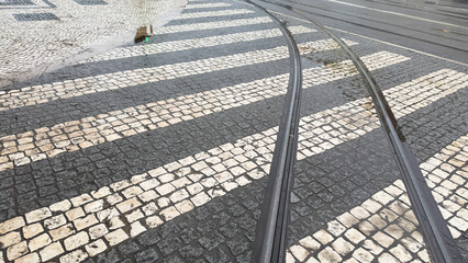 Curving tram lines kiss mosaic cobblestones in an urban symphony; celebrate Lisbons Festas de Lisboa and railway nostalgia