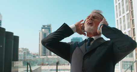 Emotional office worker in headphones singing along to favorite song, outdoor fun